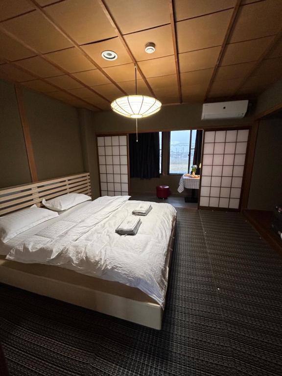 1 dormitorio con 1 cama blanca grande en una habitación en 高島市安曇川町琵琶湖徒歩3分エクシブ 高島 近くBbQ自転車無料貸出, en Takashima