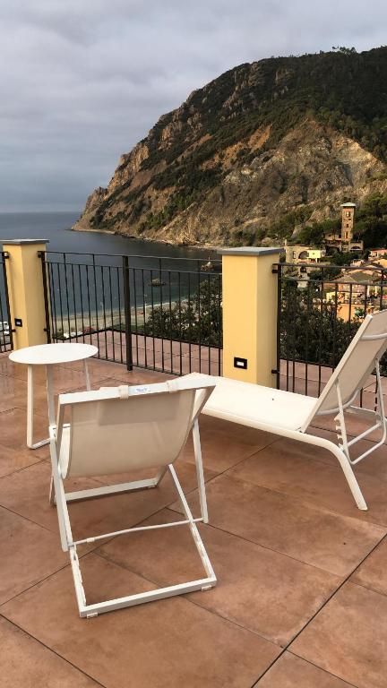 a bench and a table on a balcony with a view at Fiordarancio Room Rental in Monterosso al Mare