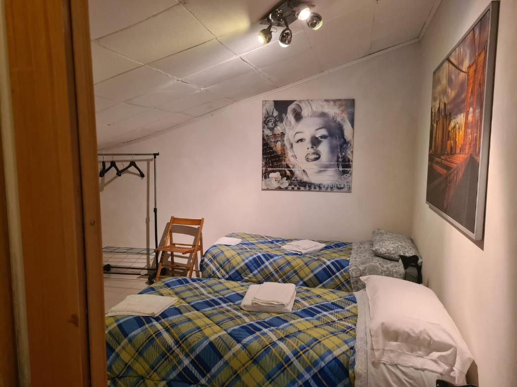 a room with two beds and a picture of a woman at La Casa di Gabry in Valledolmo