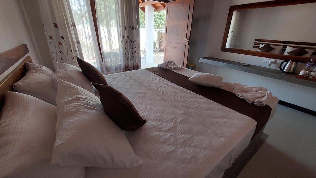 a large white bed with pillows in a bedroom at The Dream Inn Guesthouse Passikudah in Batticaloa