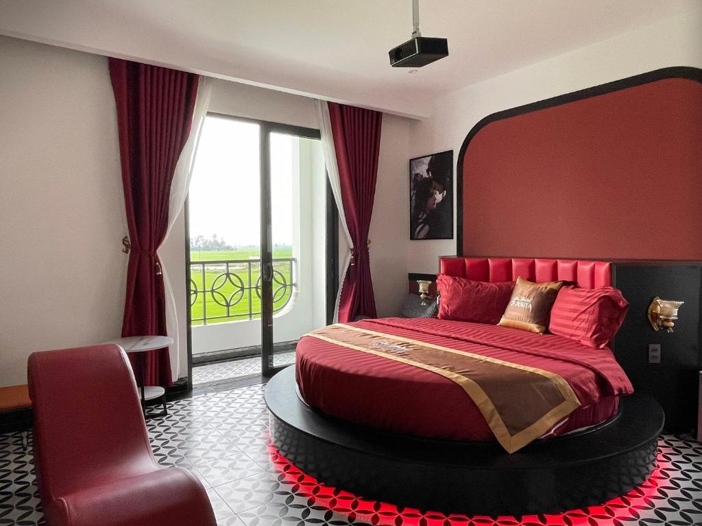 um quarto com uma cama vermelha e uma grande janela em Punita Hotel em Dien Ban