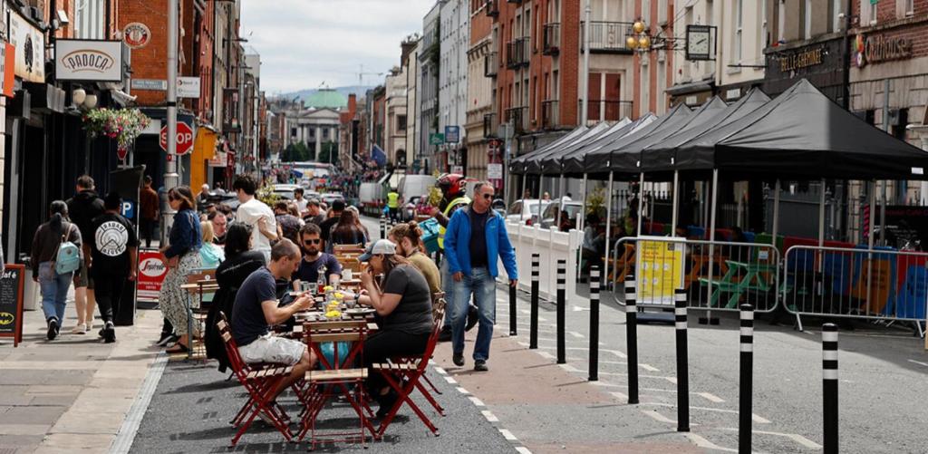 Un groupe de personnes assises à des tables dans une rue de la ville dans l'établissement Oliver's Hostel, à Dublin