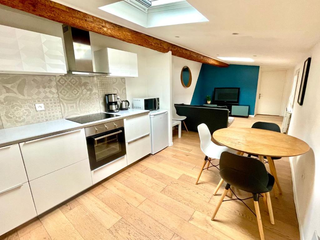 une cuisine avec une table en bois et une salle à manger dans l'établissement Place de la Comédie - Magnifique T2 au calme, à Montpellier