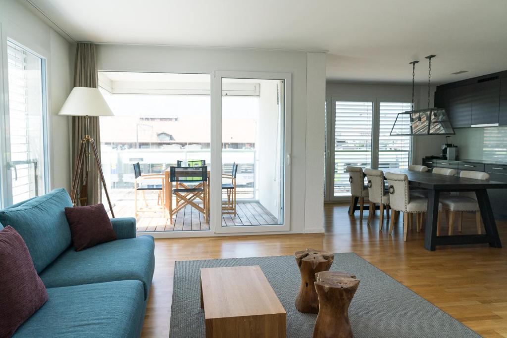 un soggiorno con divano blu e tavolo di Apartment Spedition a Thun