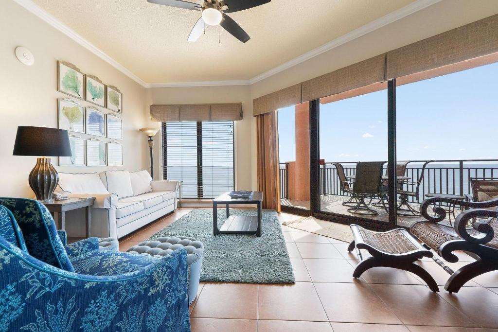 a living room with a couch and a balcony at Seachase 1503W in Orange Beach
