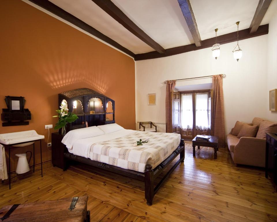 a bedroom with a large bed and a couch at Hotel Boutique La Morada de Juan de Vargas in Villanueva de los Infantes