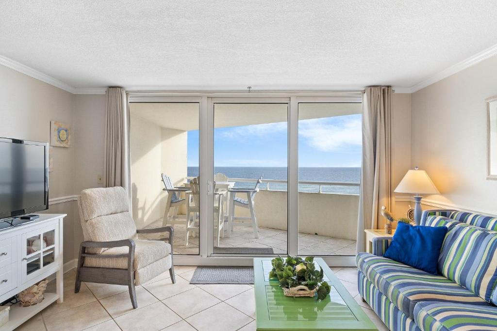 a living room with a couch and a television with a view of the ocean at Perdido Sun 512 in Perdido Key