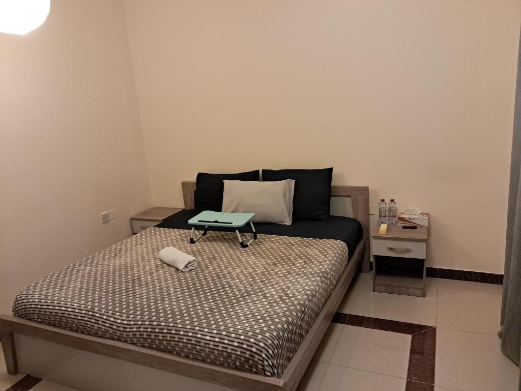 a small bedroom with a bed with a table on it at Top House Zayed Airport - Free Taxi Drop in Abu Dhabi