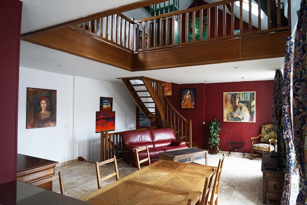 - un salon avec une table en bois et un escalier dans l'établissement Le Gîte de la Galerie d'Art, à Châtillon-sur-Seine