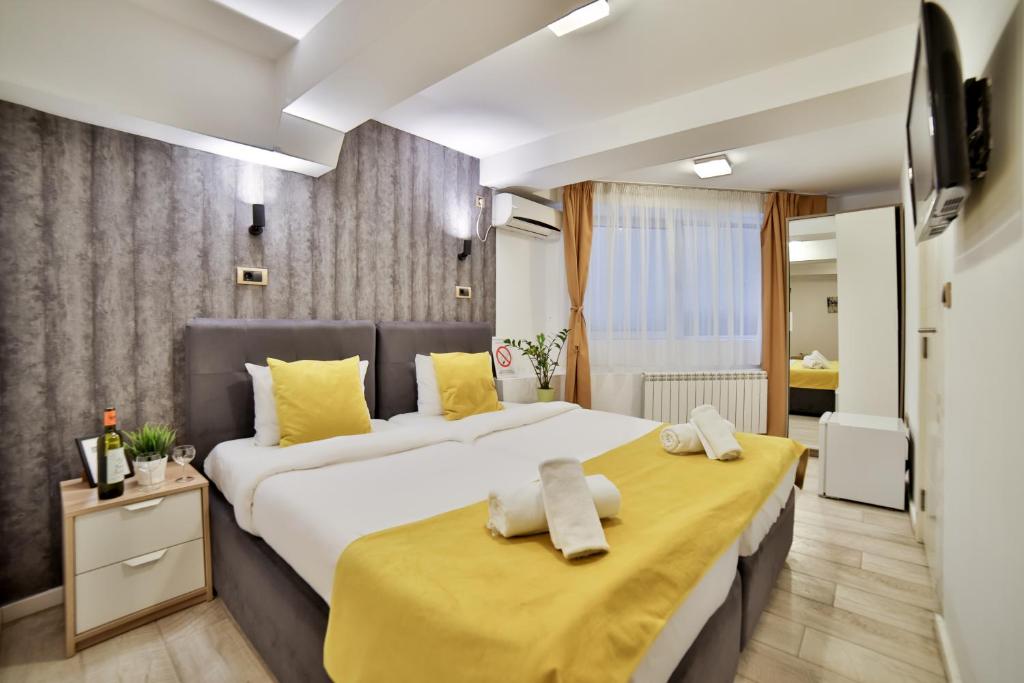 1 dormitorio con 2 camas con almohadas amarillas en Garni House 46 Plus, en Belgrado