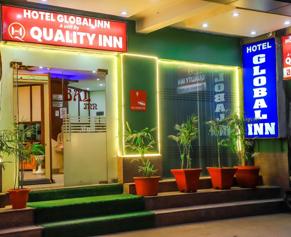a hotel entrance with potted plants in front of it at Hotel Global Inn By Quality Inn in New Delhi