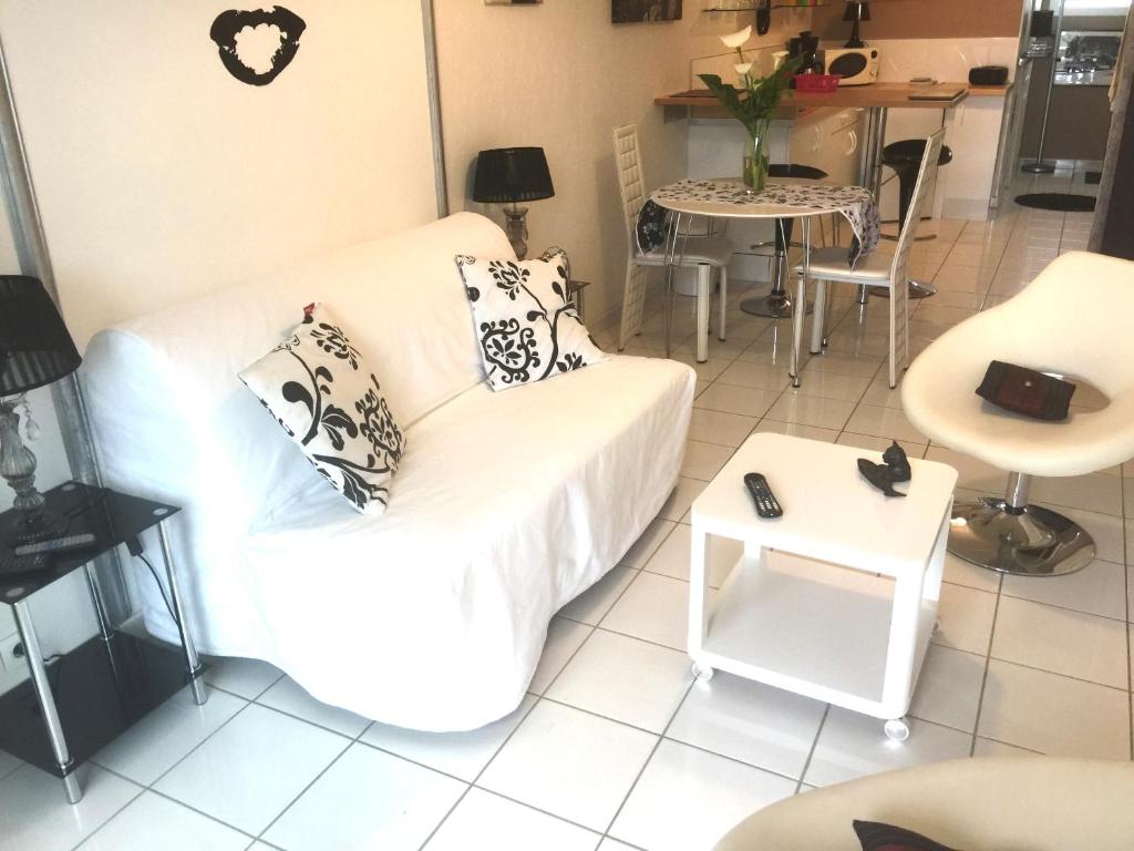Studio ou maisonnette Sarzeau في سارزو: غرفة معيشة مع أريكة بيضاء وطاولة