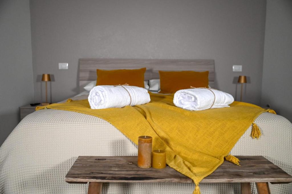 ein Bett mit einer gelben Decke und Kissen darauf in der Unterkunft Il vecchio salone in Lecce