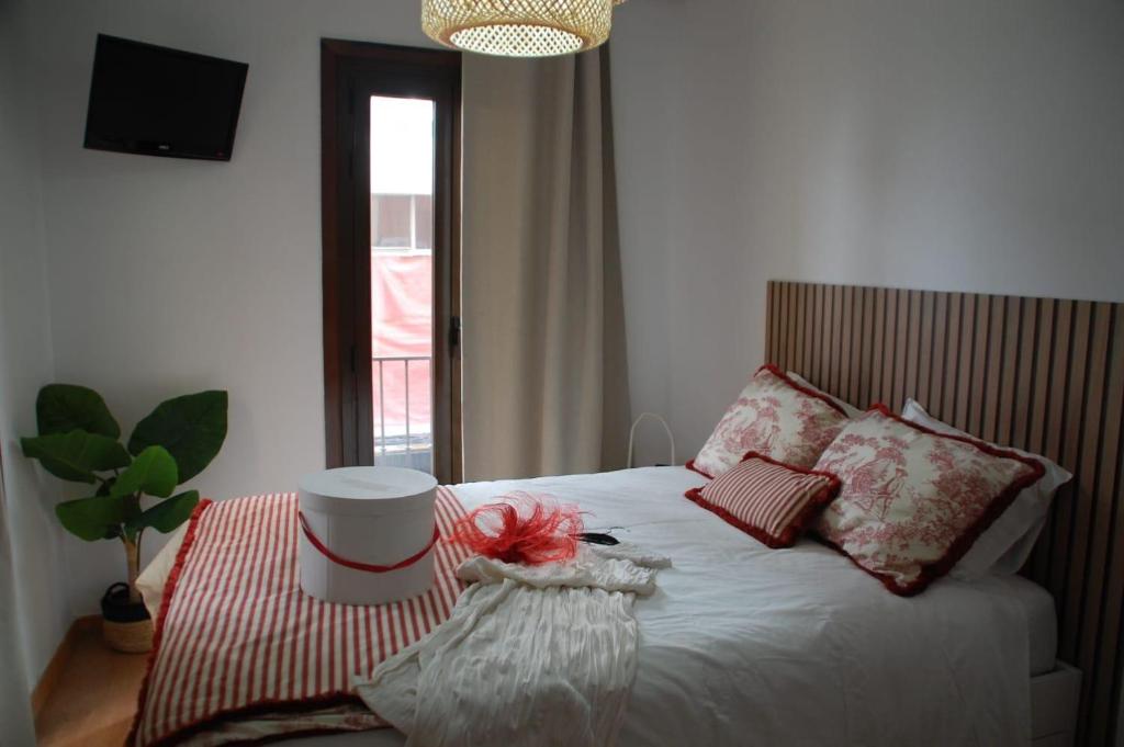 Un dormitorio con una cama y una mesa con una flor. en Markesa, en Plasencia