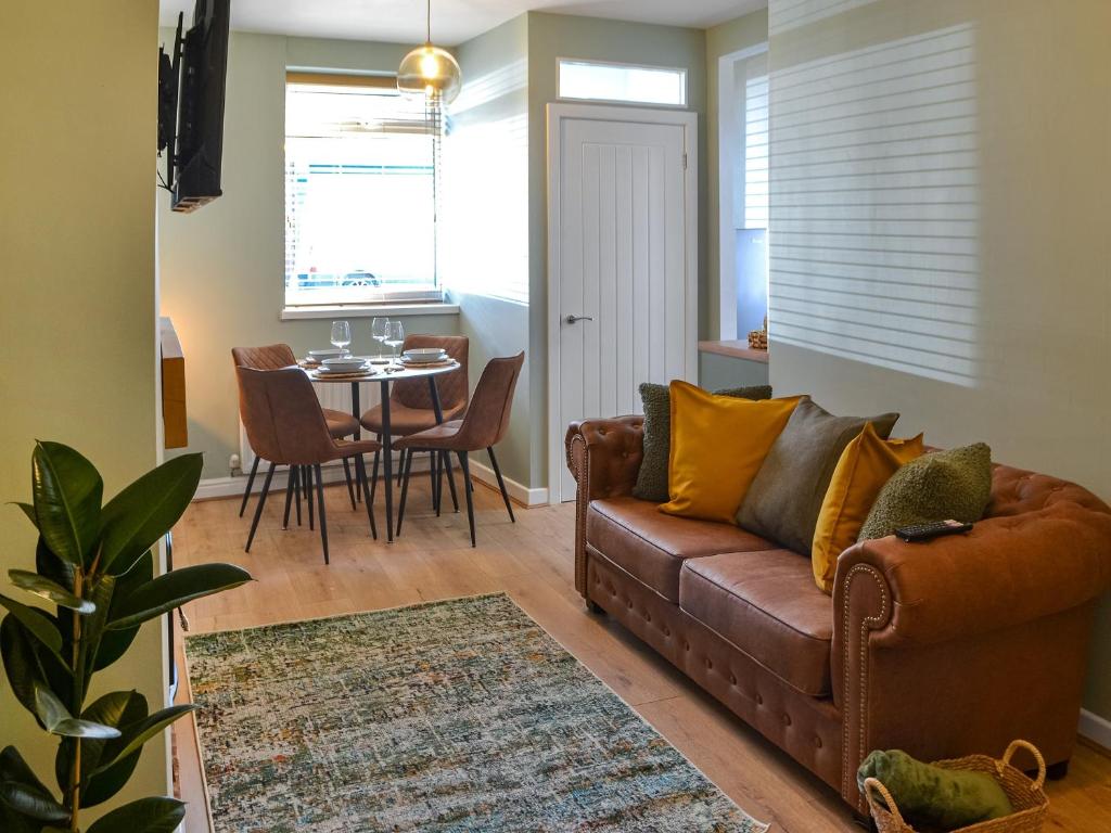 - un salon avec un canapé et une table dans l'établissement Hogarth Apartment By The Sea, à Newbiggin-by-the-Sea