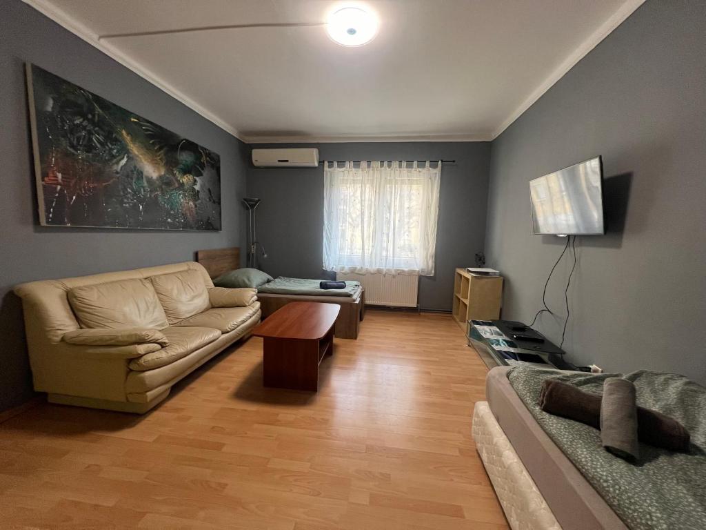 uma sala de estar com um sofá e uma mesa em Family Friendly Apartman em Budapeste