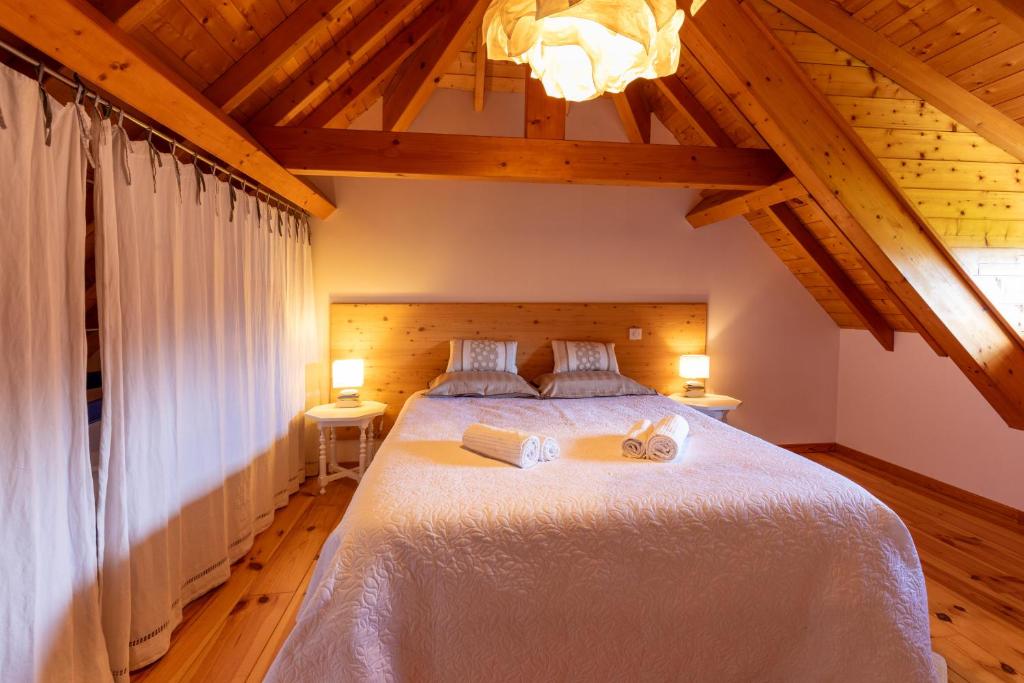 een slaapkamer met een groot wit bed met 2 lampen bij Gîte Le Bédat in Ayzac-Ost