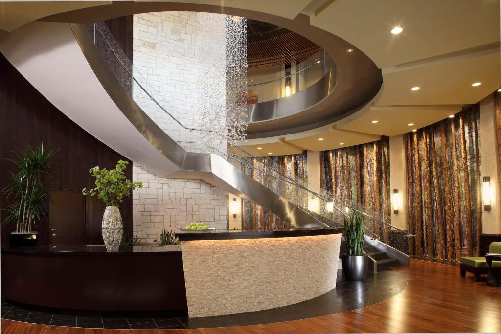 a lobby with a spiral staircase in a building at Hyatt Centric The Woodlands in The Woodlands