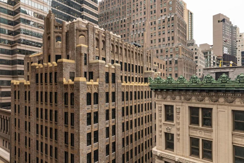 a tall building in a city with tall buildings at Hyatt Centric Wall Street New York in New York