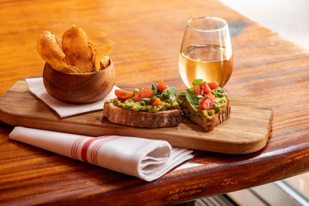 a wooden table with a plate of food and a glass of beer at Hyatt Centric Wall Street New York in New York