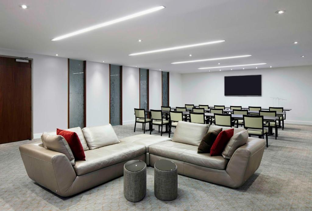 a conference room with two couches and a table and chairs at Hyatt Centric Wall Street New York in New York