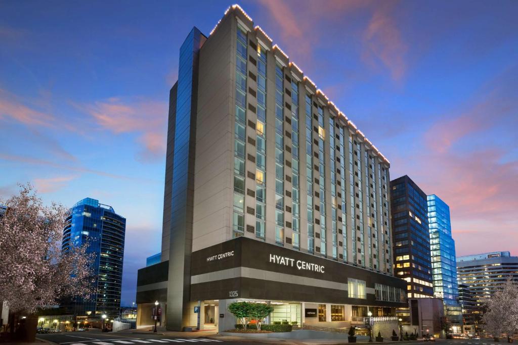 a tall building with a hotel centre in a city at Hyatt Centric Arlington in Arlington