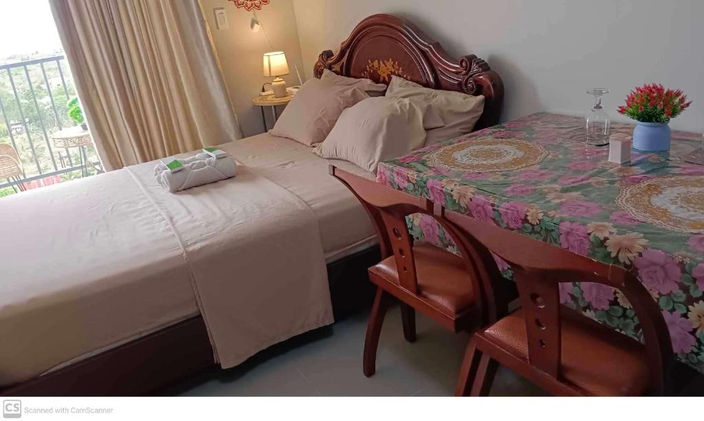 1 dormitorio con 1 cama y 1 mesa con sillas en Adam&Eva Condo Staycation, en Lapu Lapu City