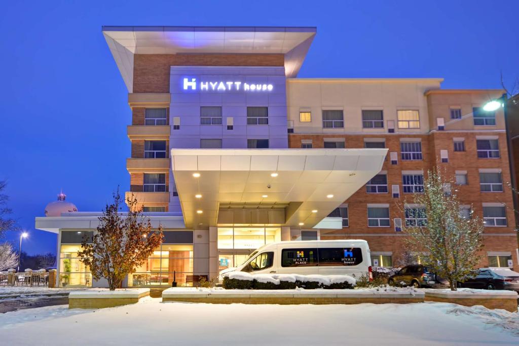 a building with a van parked in front of it at Hyatt House Naperville/Warrenville in Warrenville