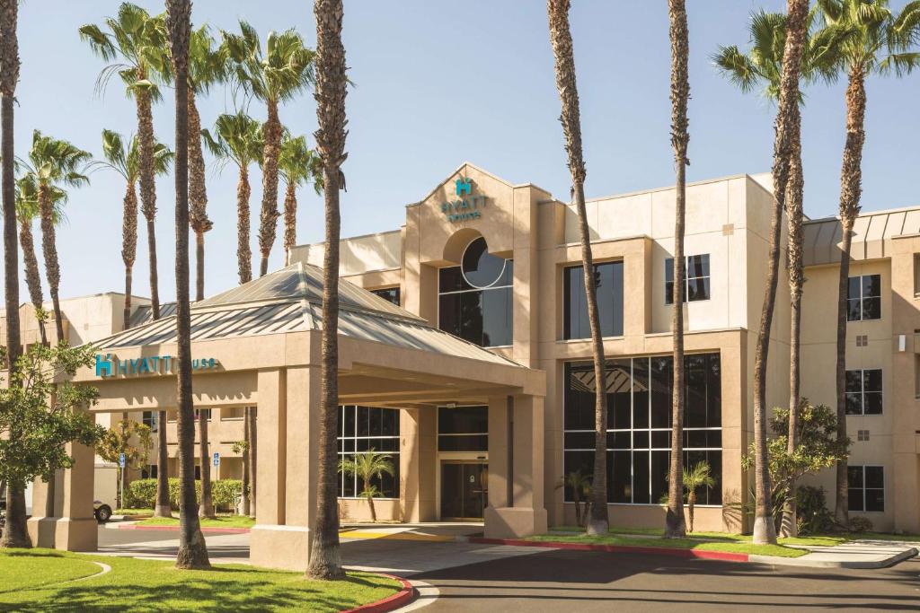 a building with palm trees in front of it at Hyatt House Cypress / Anaheim in Cypress