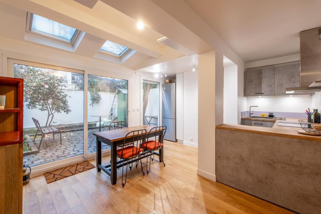 une cuisine et une salle à manger avec une table et des chaises dans l'établissement Malakoff - Cosy appartement tout équipé aux portes de Paris, à Malakoff