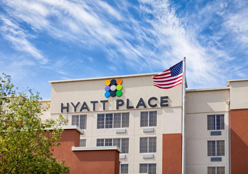 a hyatt place building with an american flag on top at Hyatt Place Columbus-North in Columbus