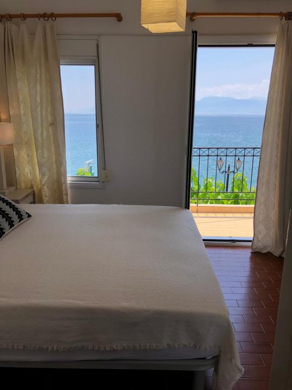 a bedroom with a bed and a view of the ocean at Studios on the beach in Galaxidi