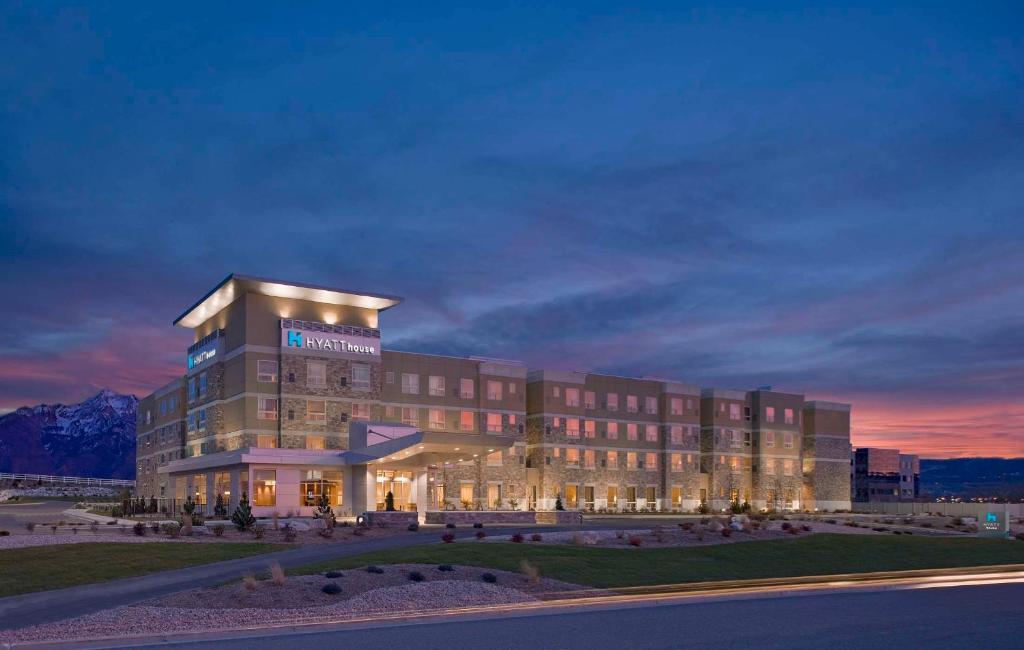 a hotel building with a sunset in the background at Hyatt House Salt Lake City/Sandy in Sandy