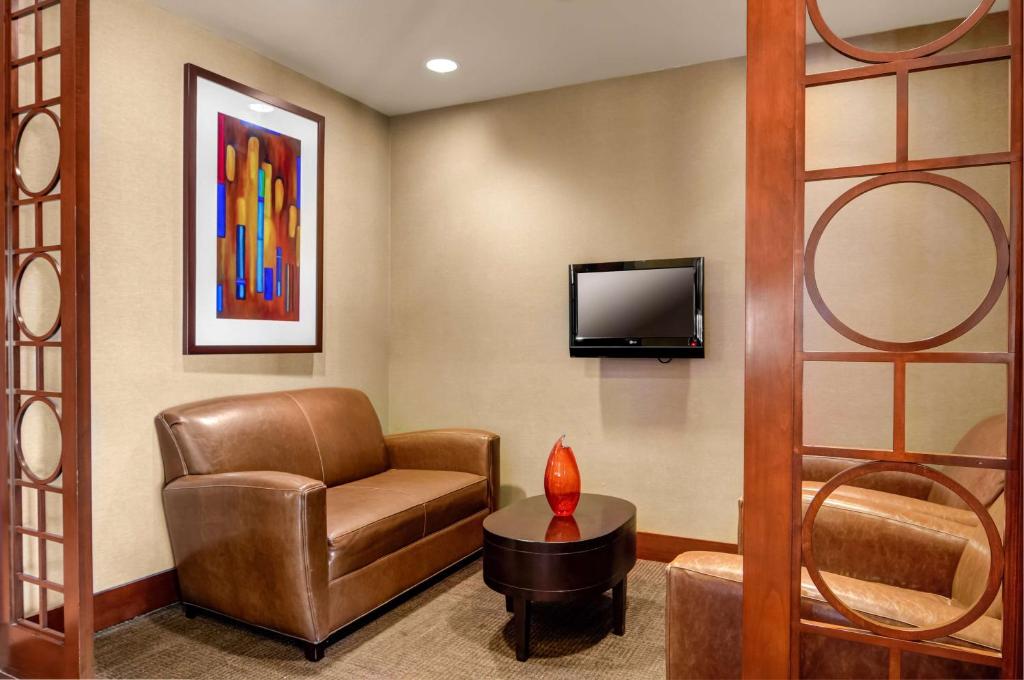 a waiting room with a chair and a tv at Hyatt Place Charlotte Airport/Lake Pointe in Charlotte