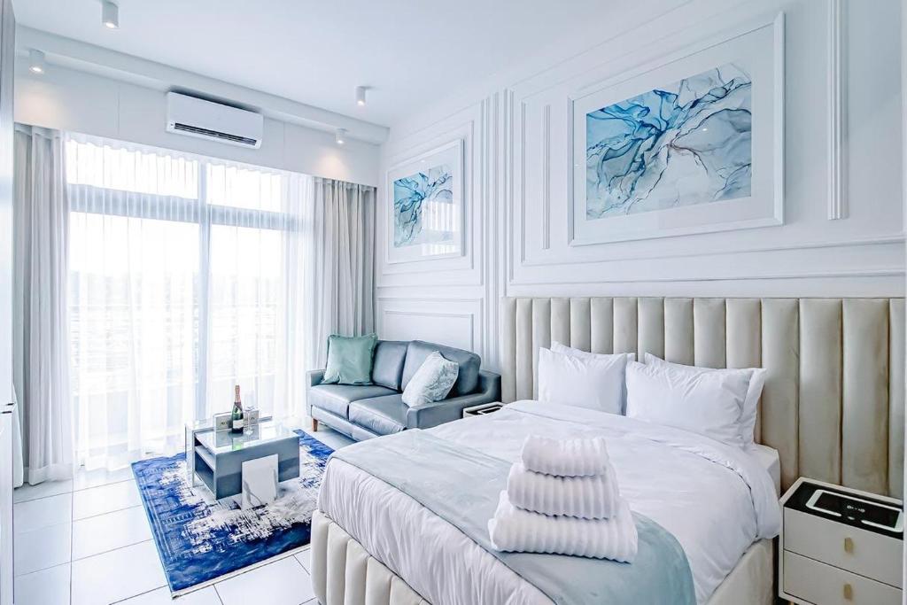 a bedroom with a bed and a couch and a chair at Menlyn Maine Luxury Apartments 11th & 14th floor with Balcony in Pretoria