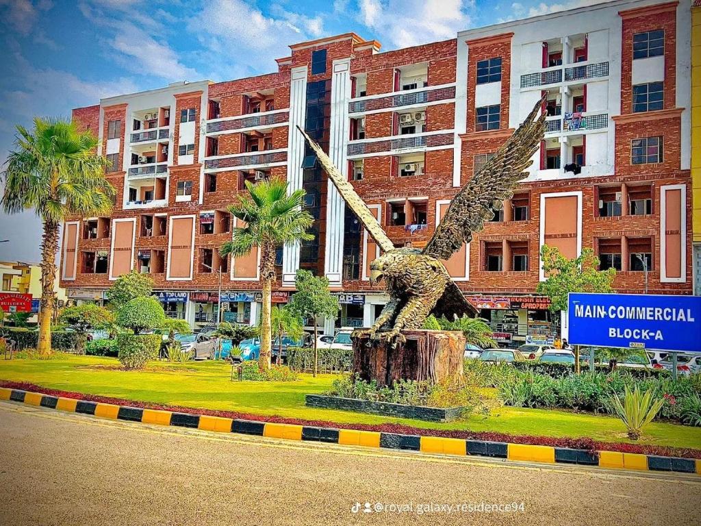 a statue of a bird in front of a building at Royal Galaxy Residence & Hotel Apartments - Near to Islamabad International Airport & Motorway in Islamabad