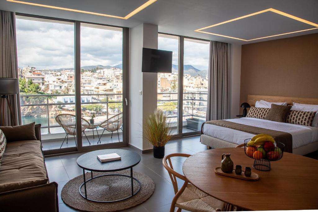 um quarto de hotel com uma cama, um sofá e uma mesa em Remvi apartments em Agios Nikolaos