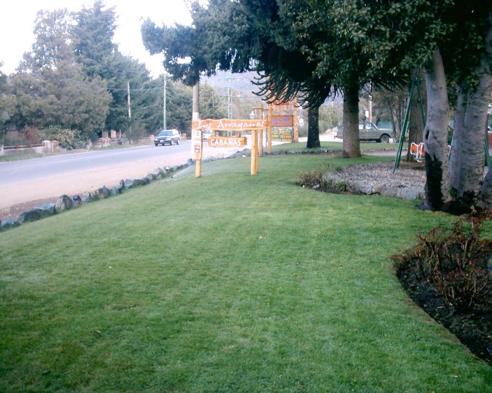 um sinal na relva ao lado de uma estrada em Complejo Los Arrayanes em San Carlos de Bariloche