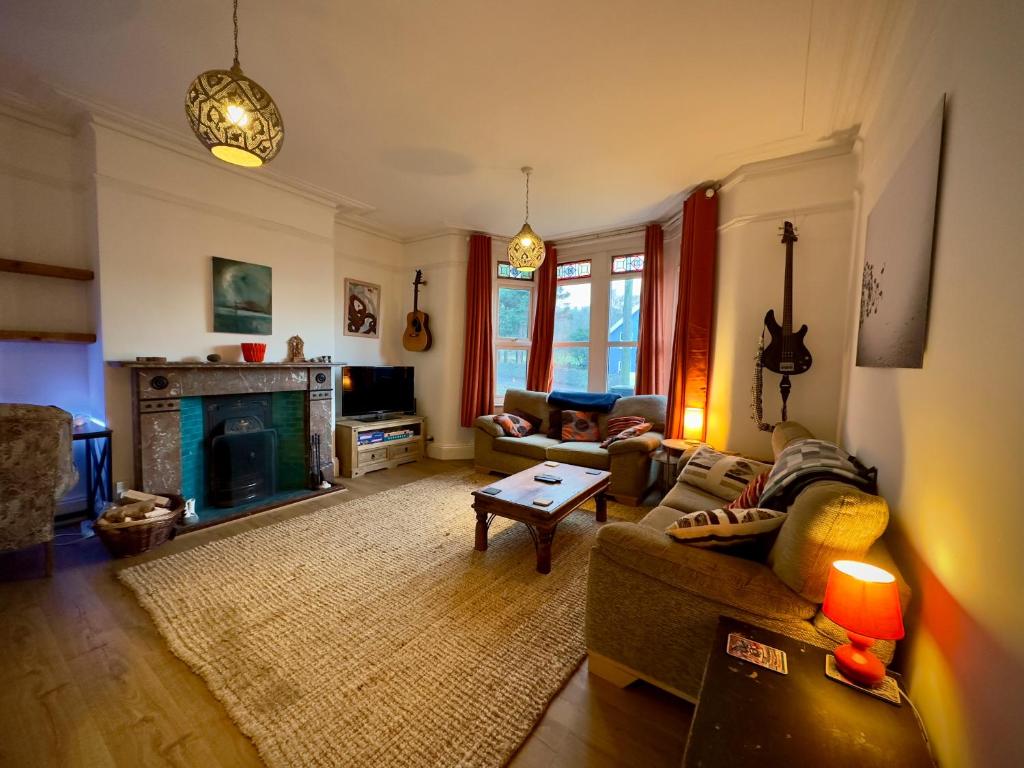 a living room with a couch and a fireplace at Victorian Cottage Like Charm with Modern Comforts in Bristol
