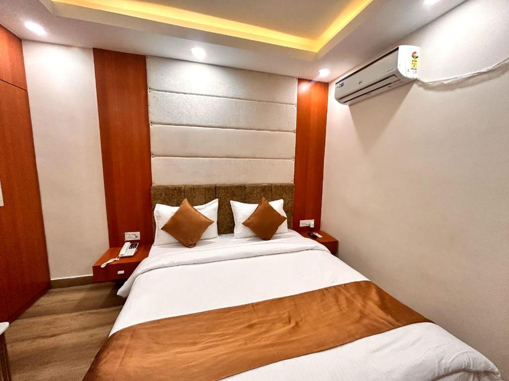 1 dormitorio con 1 cama grande con sábanas y almohadas blancas en HOTEL EDEN GARDEN en Āsansol