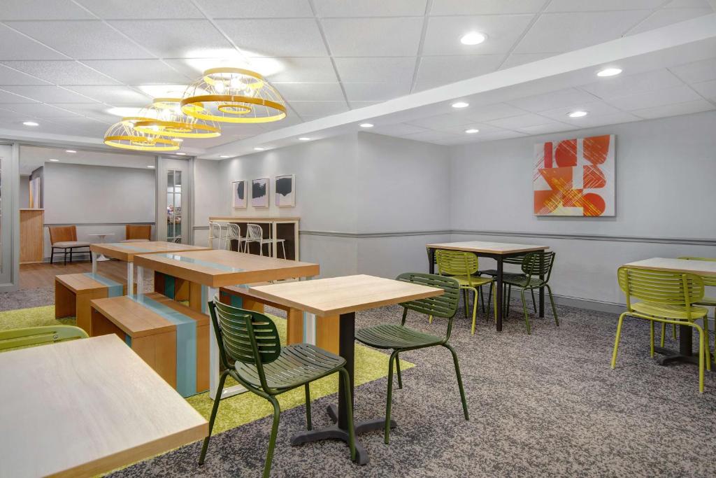 une salle d'attente avec des tables et des chaises dans un bâtiment dans l'établissement Spark By Hilton Rochester University Area, à Rochester