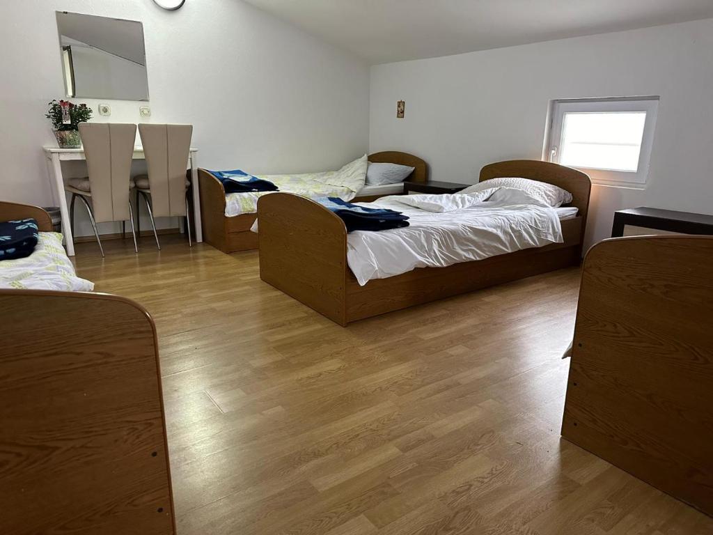 um quarto com 2 camas e uma cozinha com uma mesa em Apartments Modana em Medjugorje