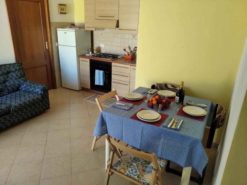 a kitchen with a table with a blue table cloth at PM 6 Via Giovanni Giolitti Guest House in Alghero