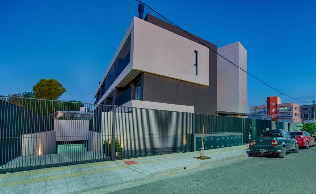budynek z samochodem zaparkowanym przed nim w obiekcie Apartamento Luxury Vistas E w mieście Neuquén