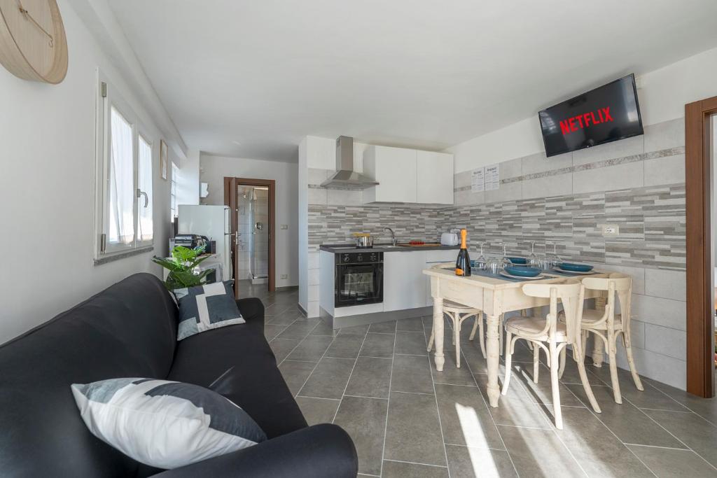 un salon avec un canapé et une table et une cuisine dans l'établissement La Maison Paradiso - vista panoramica & giardino, à Alpette