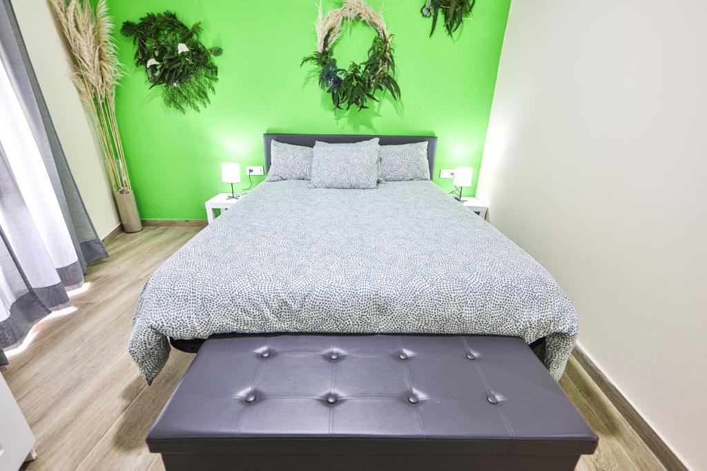 a bedroom with a large bed and green walls at A Casa de Isaura in Camariñas