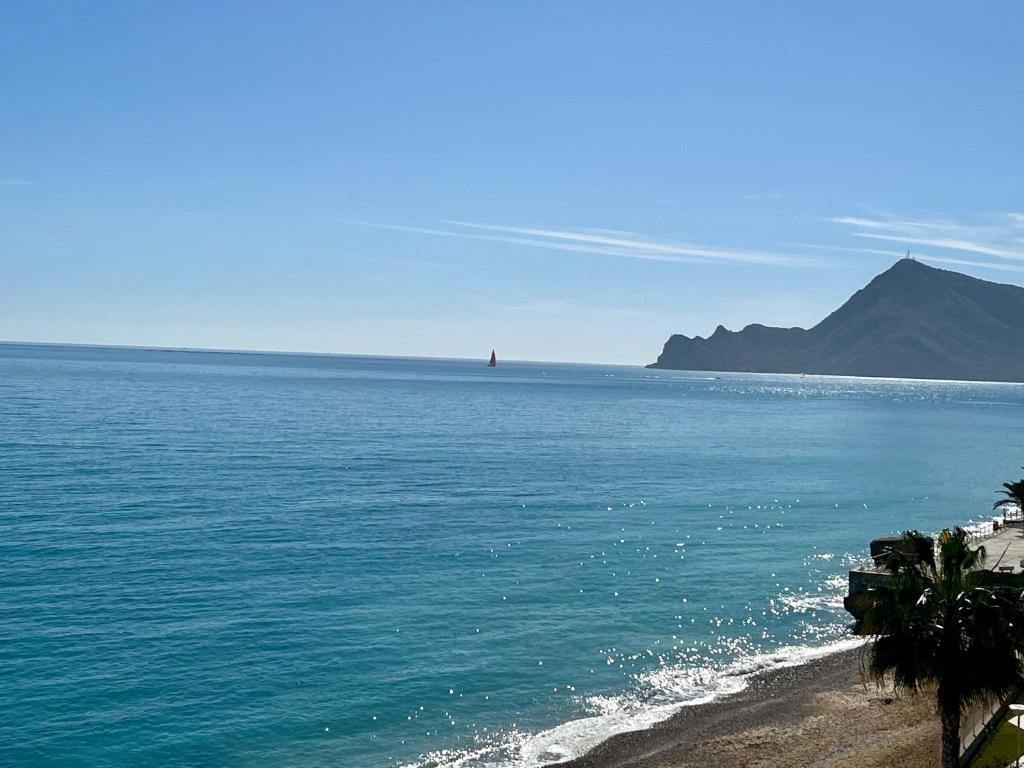 a view of the ocean with a red lighthouse in the distance at Altea Sound of the Sea in Altea
