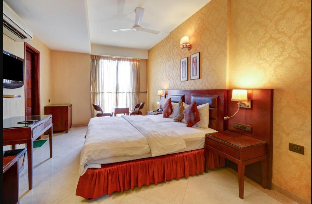 a large bedroom with a large bed and a desk at HOTEL RK REGENCY in Ahmedabad