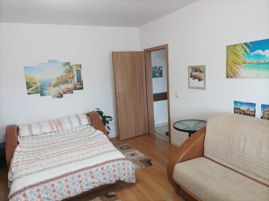 a bedroom with a bed and a couch at Apartament Alex in Alba Iulia