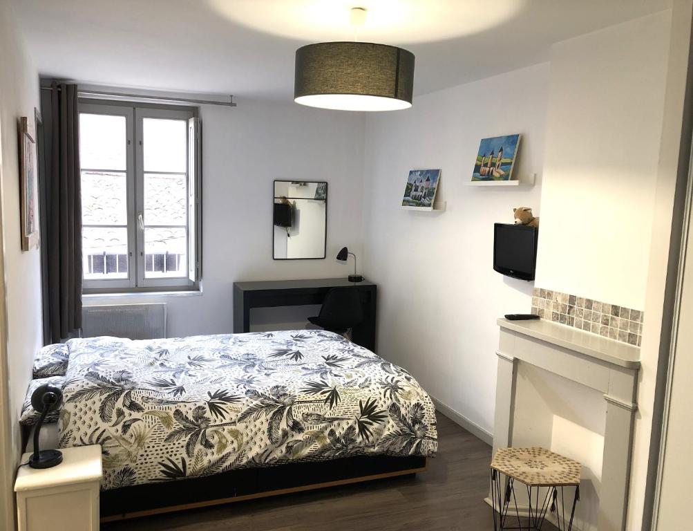 1 dormitorio con cama y ventana en La Donzelle, en Cahors